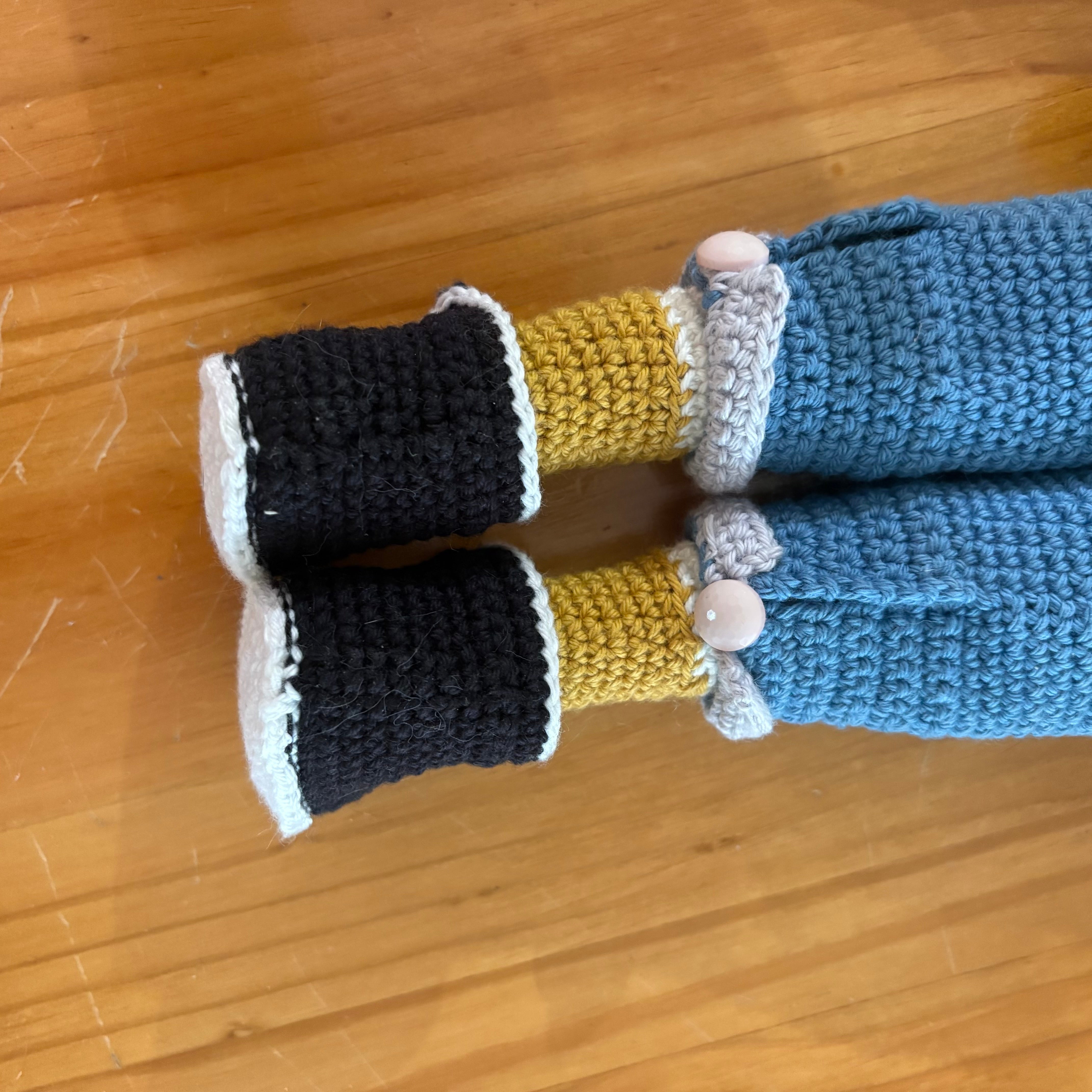 Crochet doll in overalls and beanie.