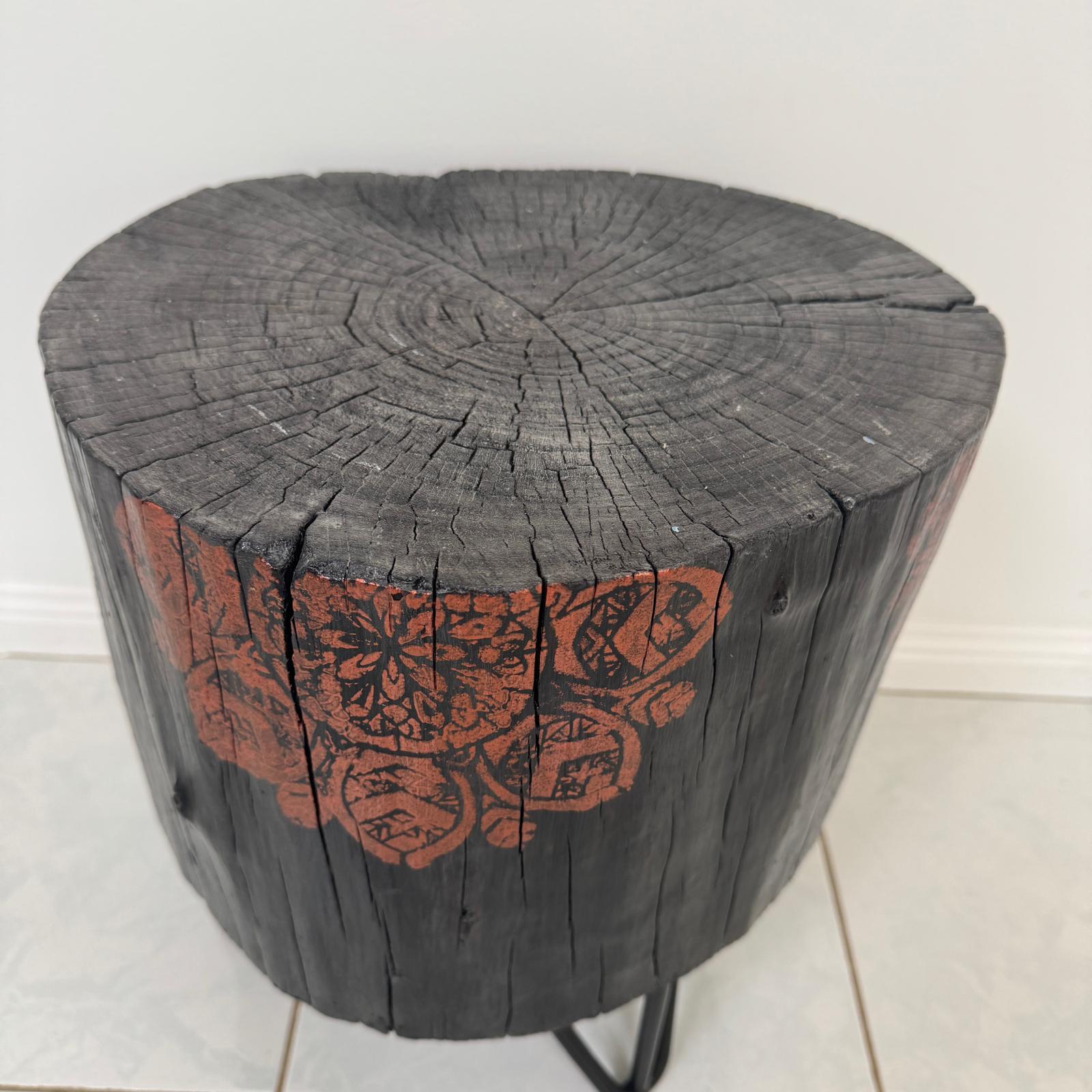 Burnt timber stump table featuring copper mandala artwork