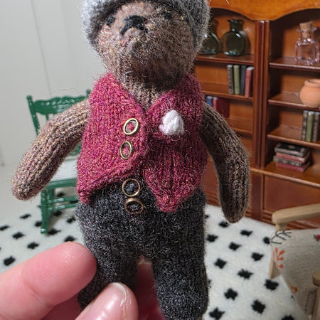 Small hand knitted bear with removeable clothes