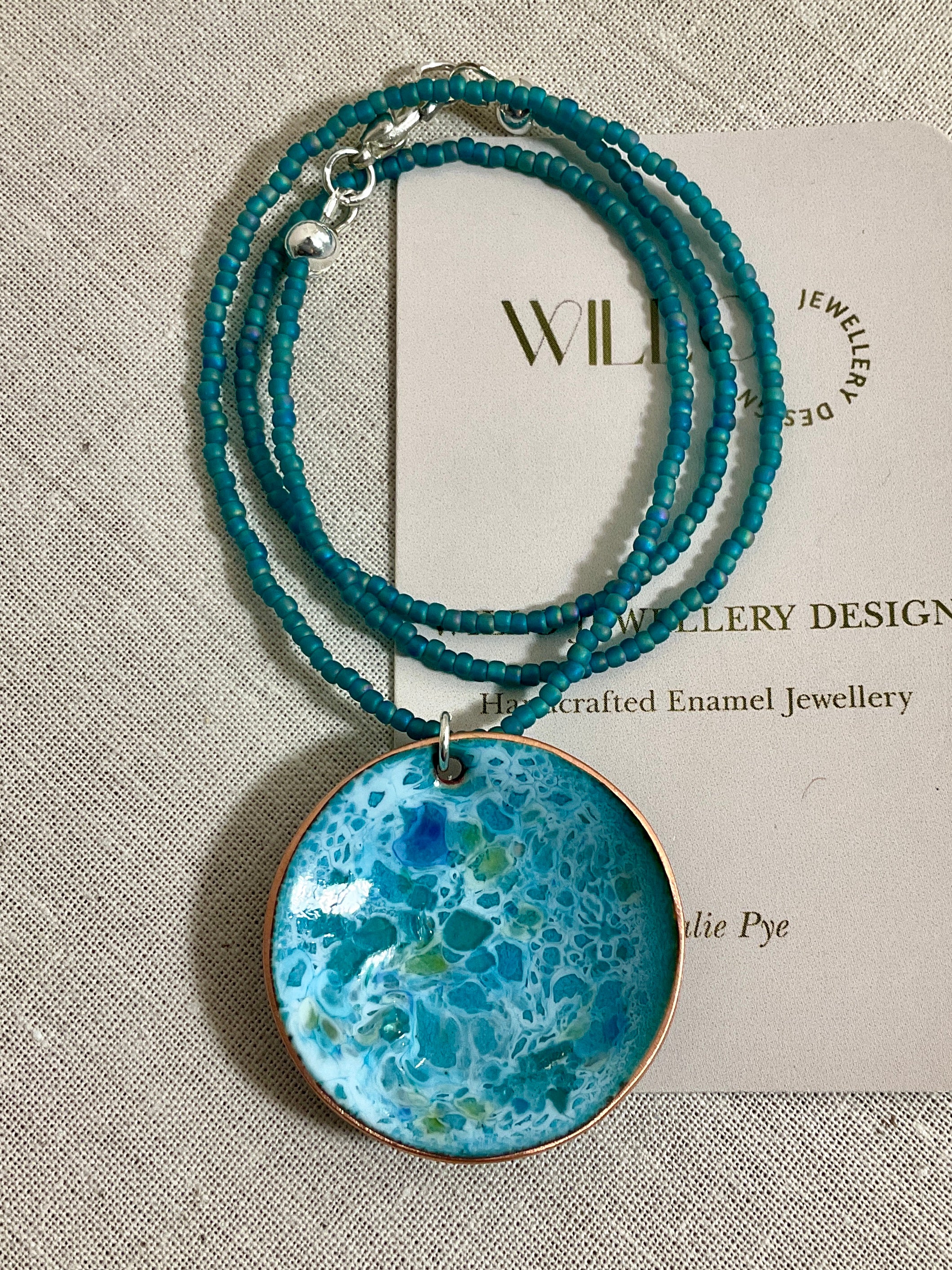Blue and green enamel pendant on glass seed beads