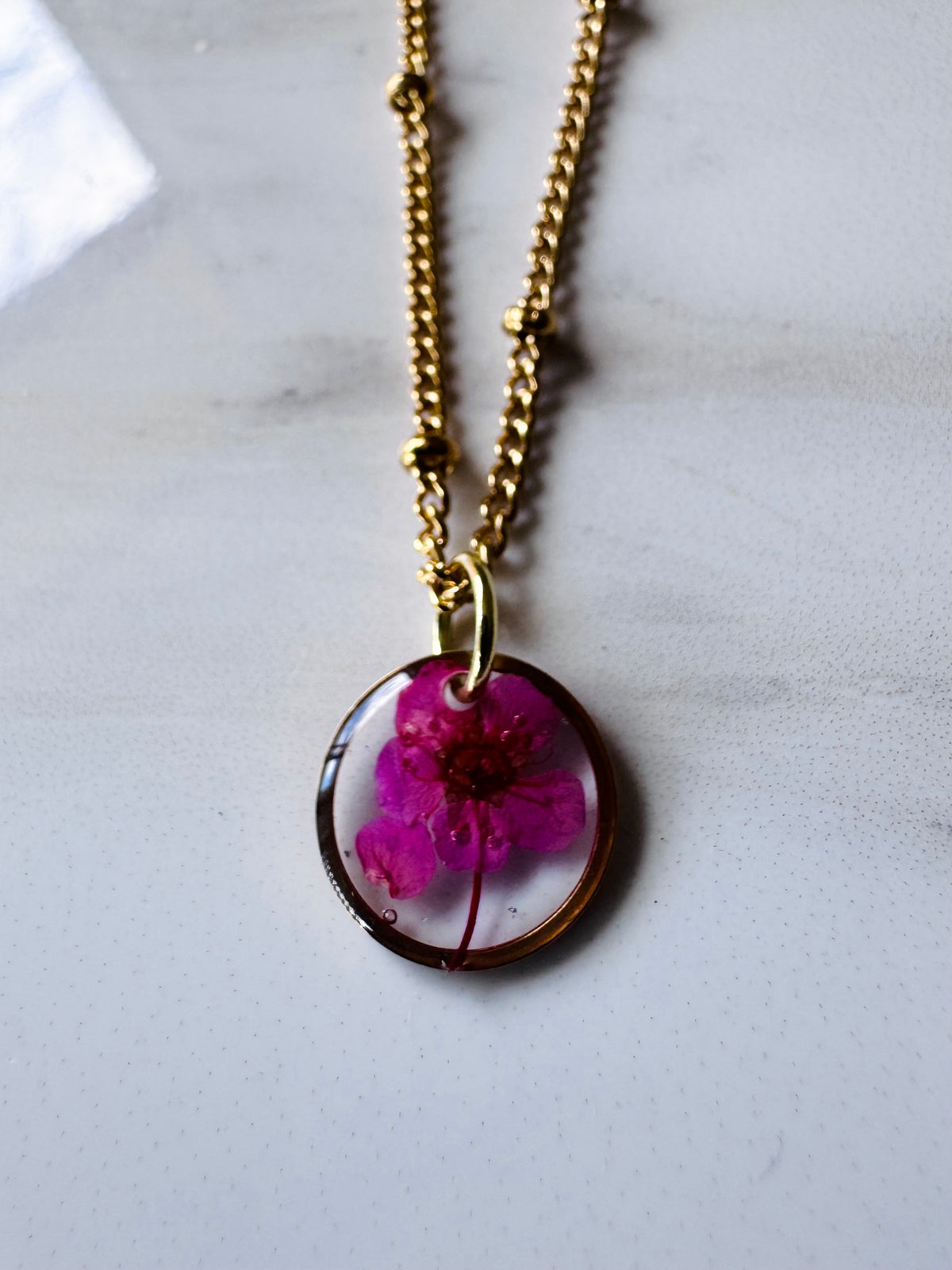 Gold plated resin necklace with fuchsia pink wildflower