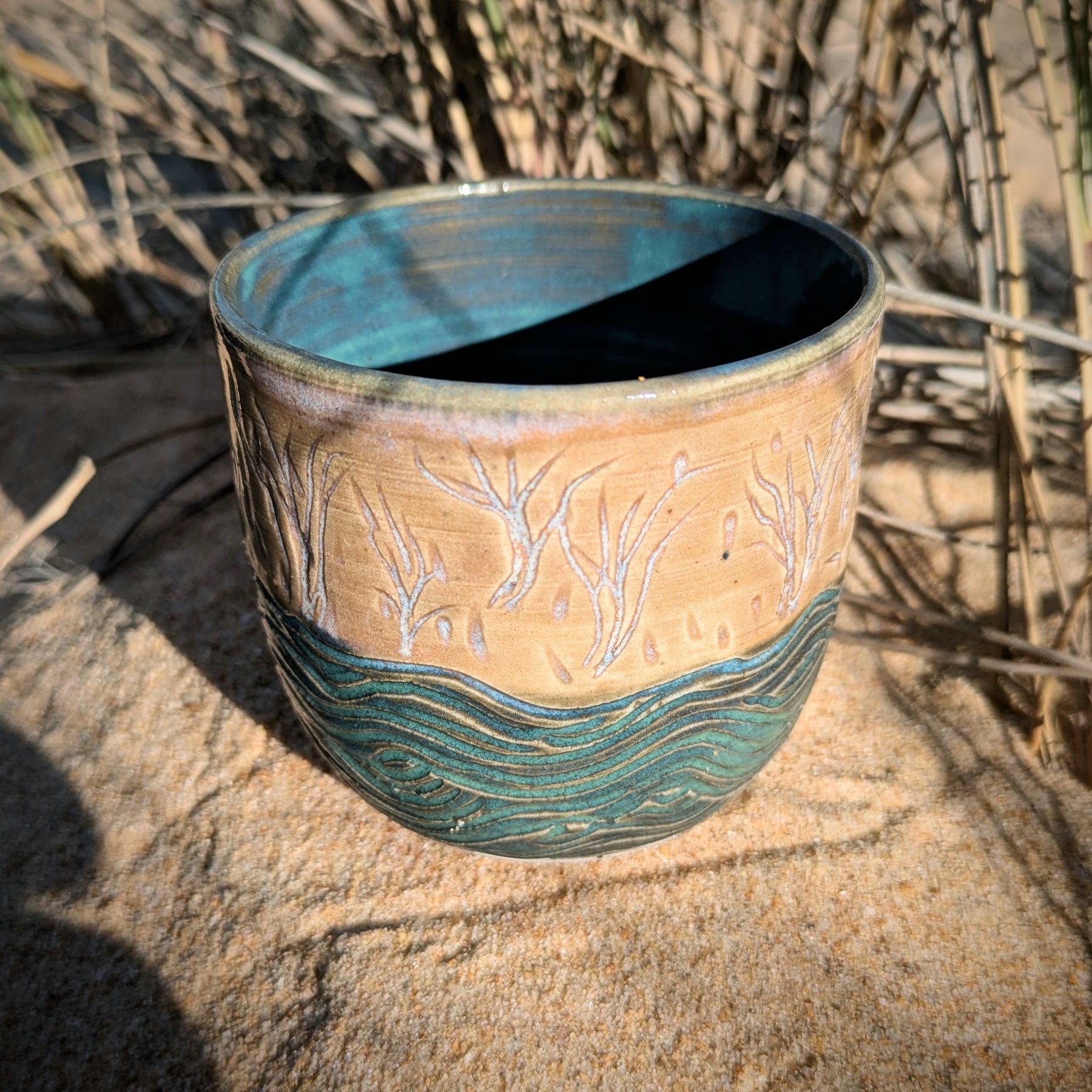 Sand dunes reeds and water tumbler