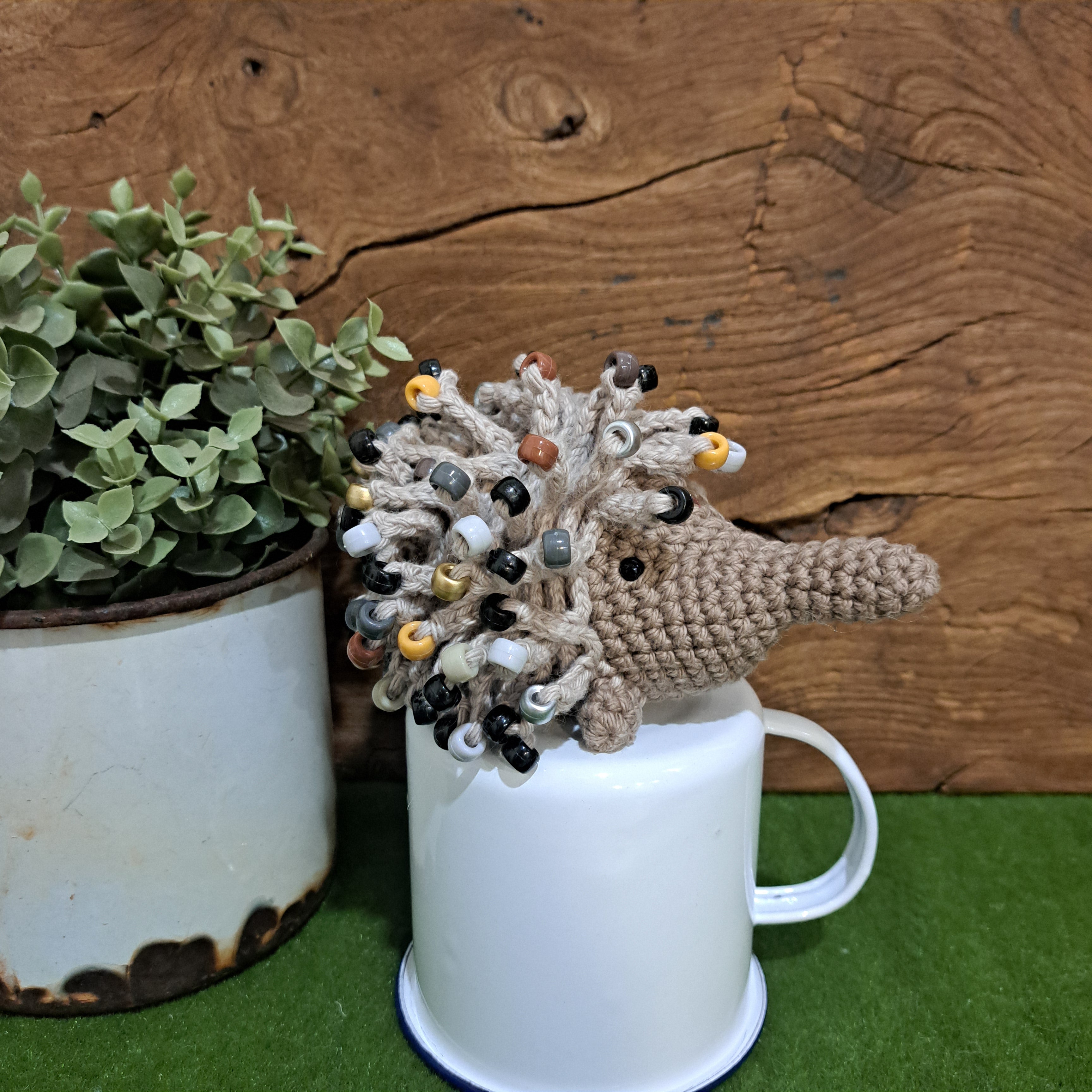 Handmade crochet echidna in beige cotton with neutral coloured beads