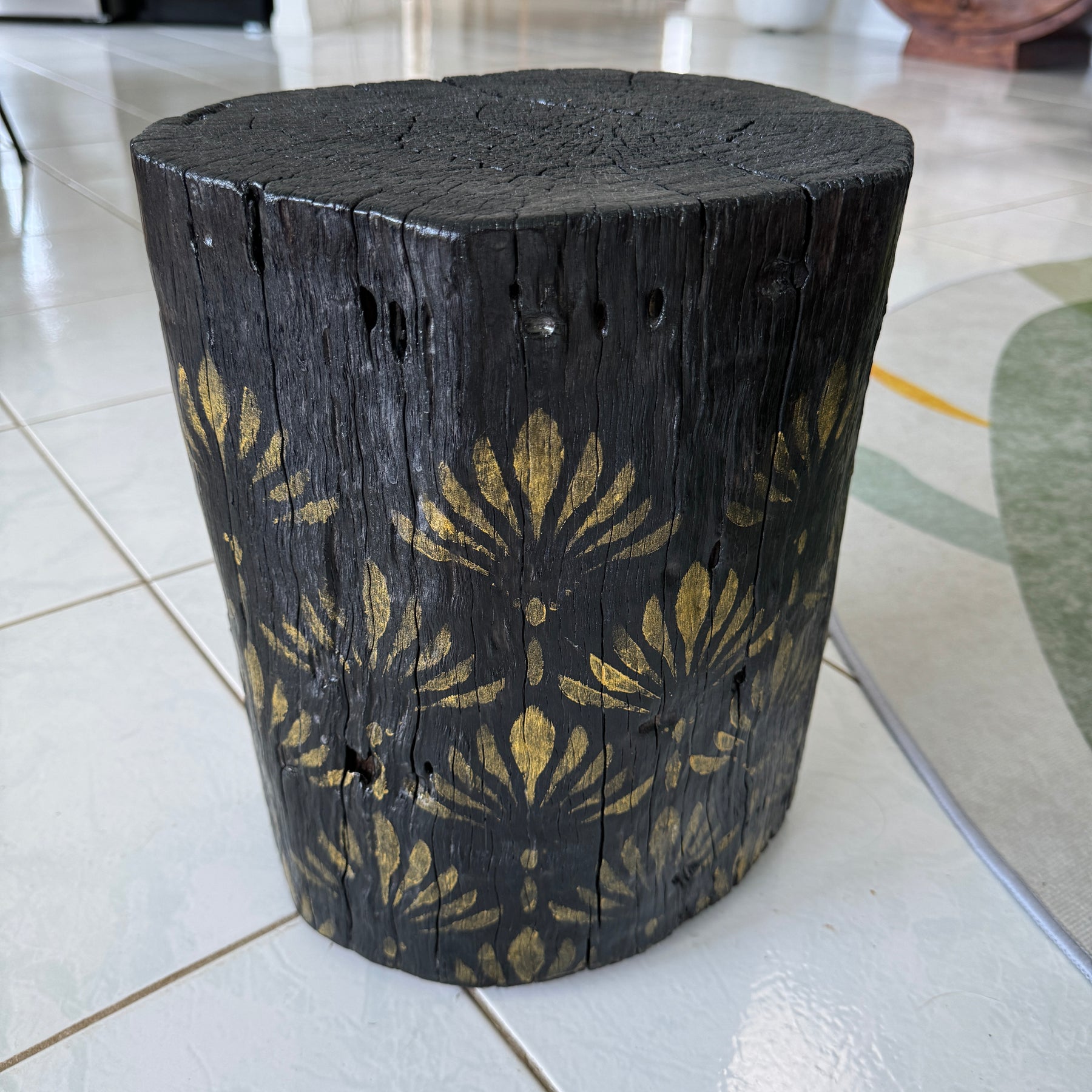 Burnt Timber stump table featuring gold hand-painted artwork