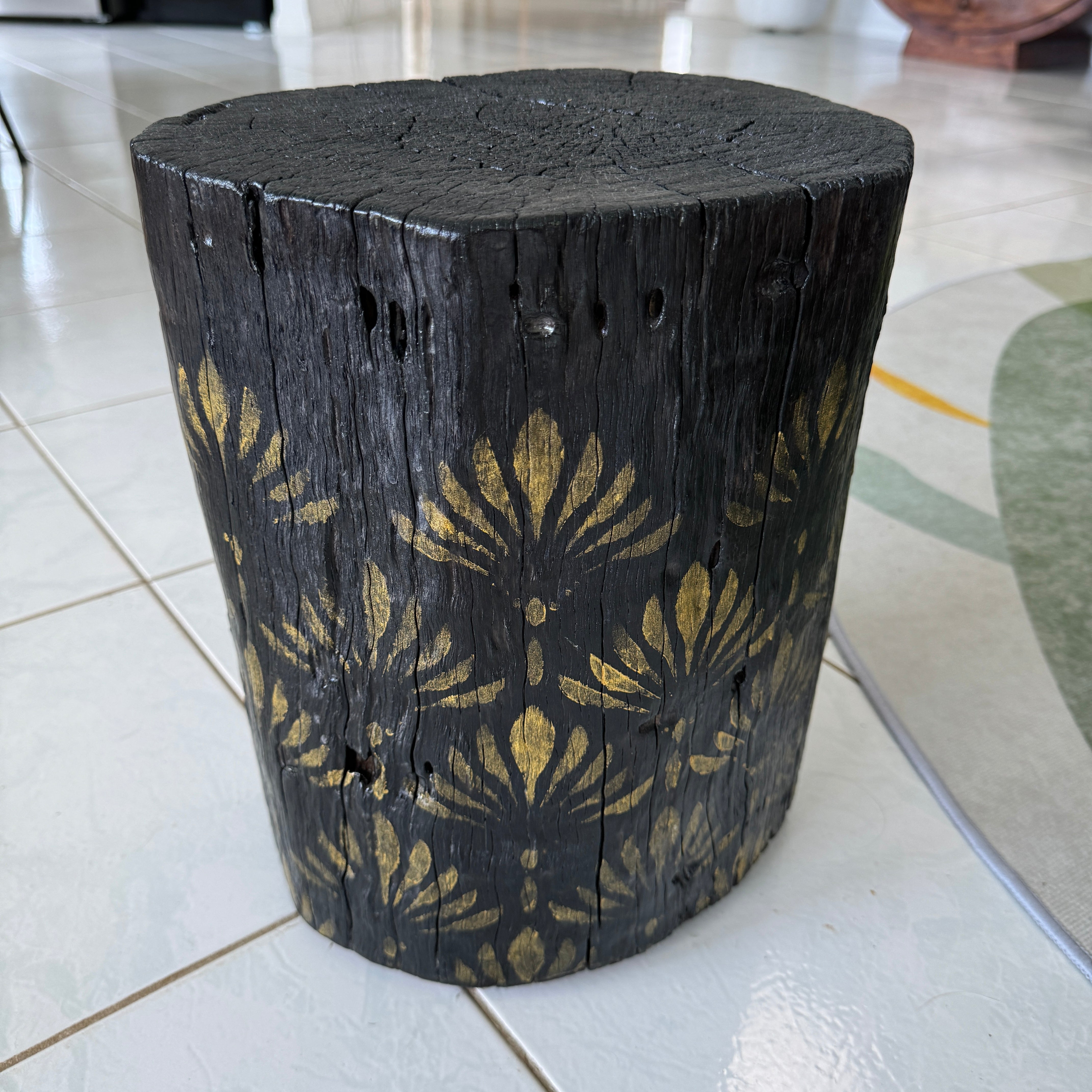 Burnt Timber stump table featuring gold hand-painted artwork