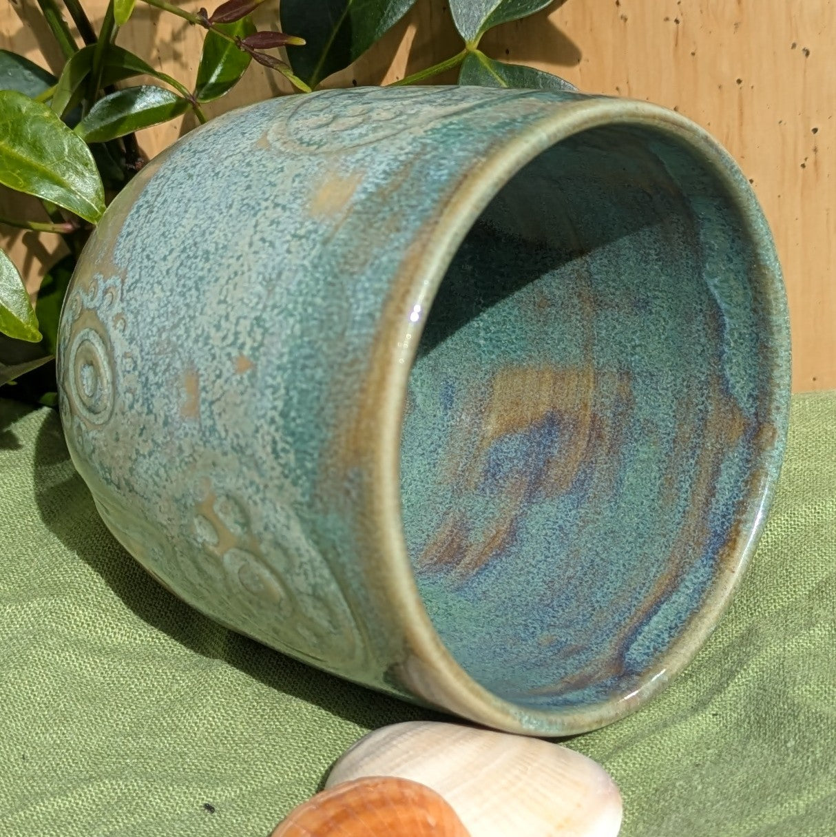 Cup in soft, mottled mossy greens and warm sandy colour