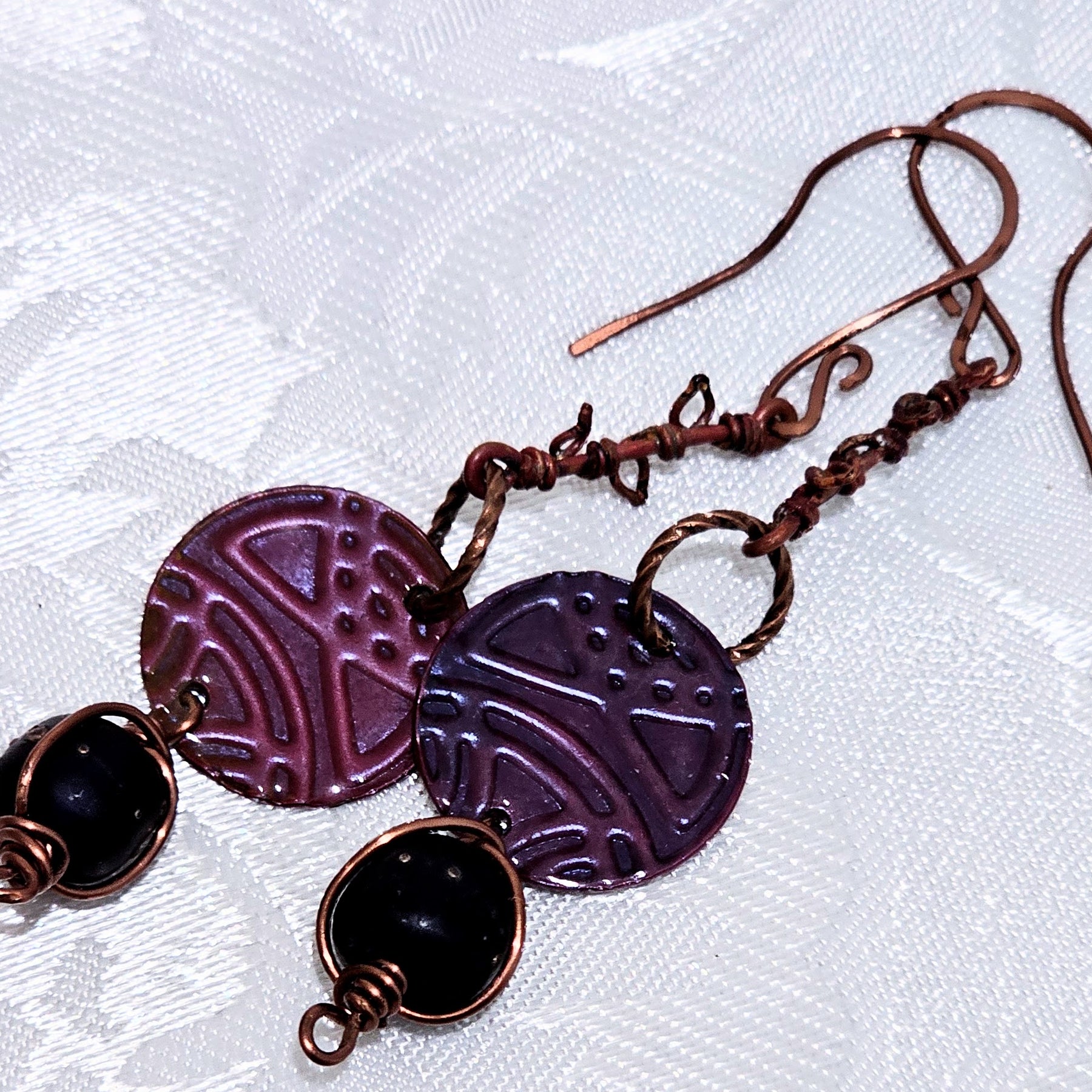 Suspended Pressed Metal Discs with Barbed Wirework Link and Black Matt Lampwork bead