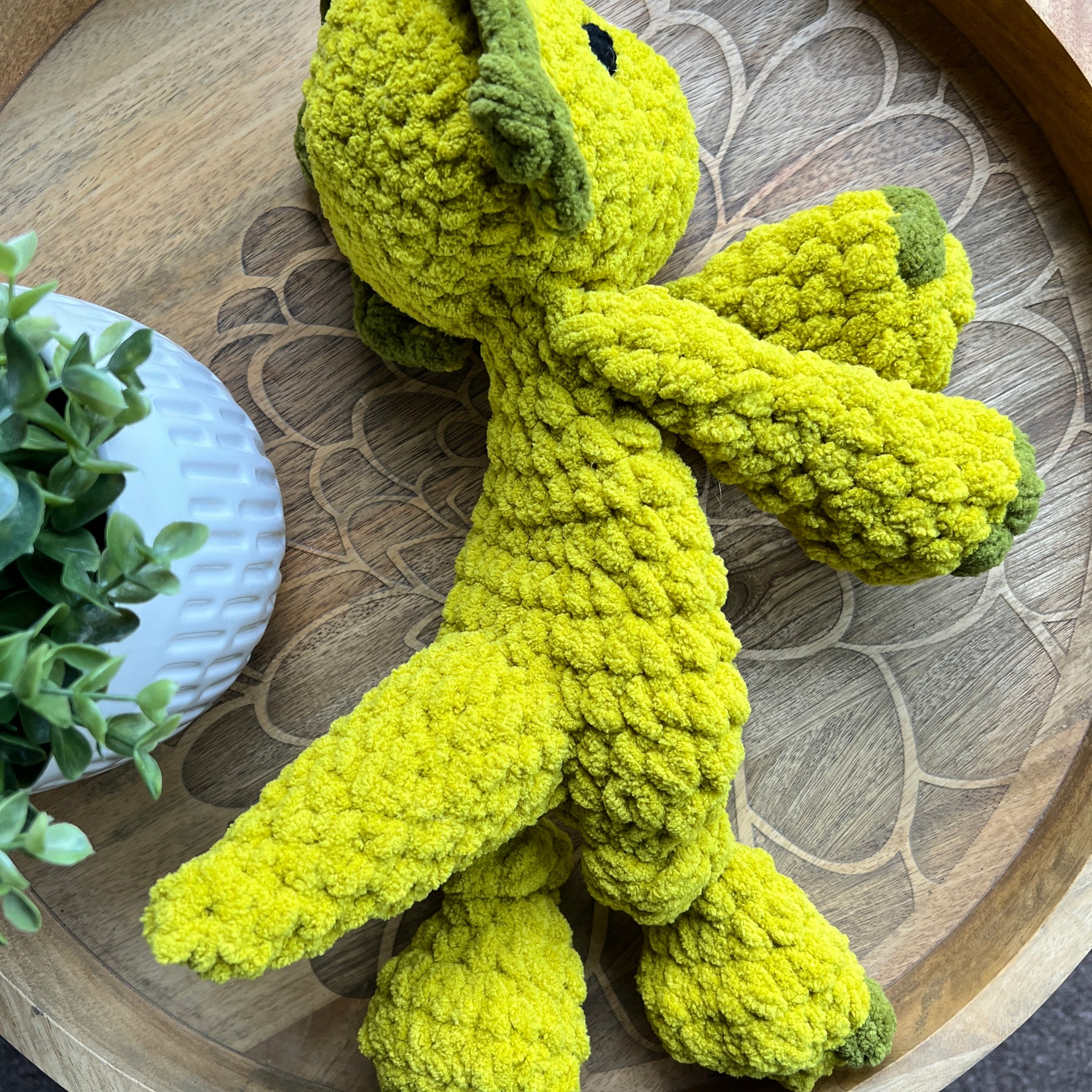 Handmade modern crochet Triceratops lovey snuggler with knotted legs baby safe.