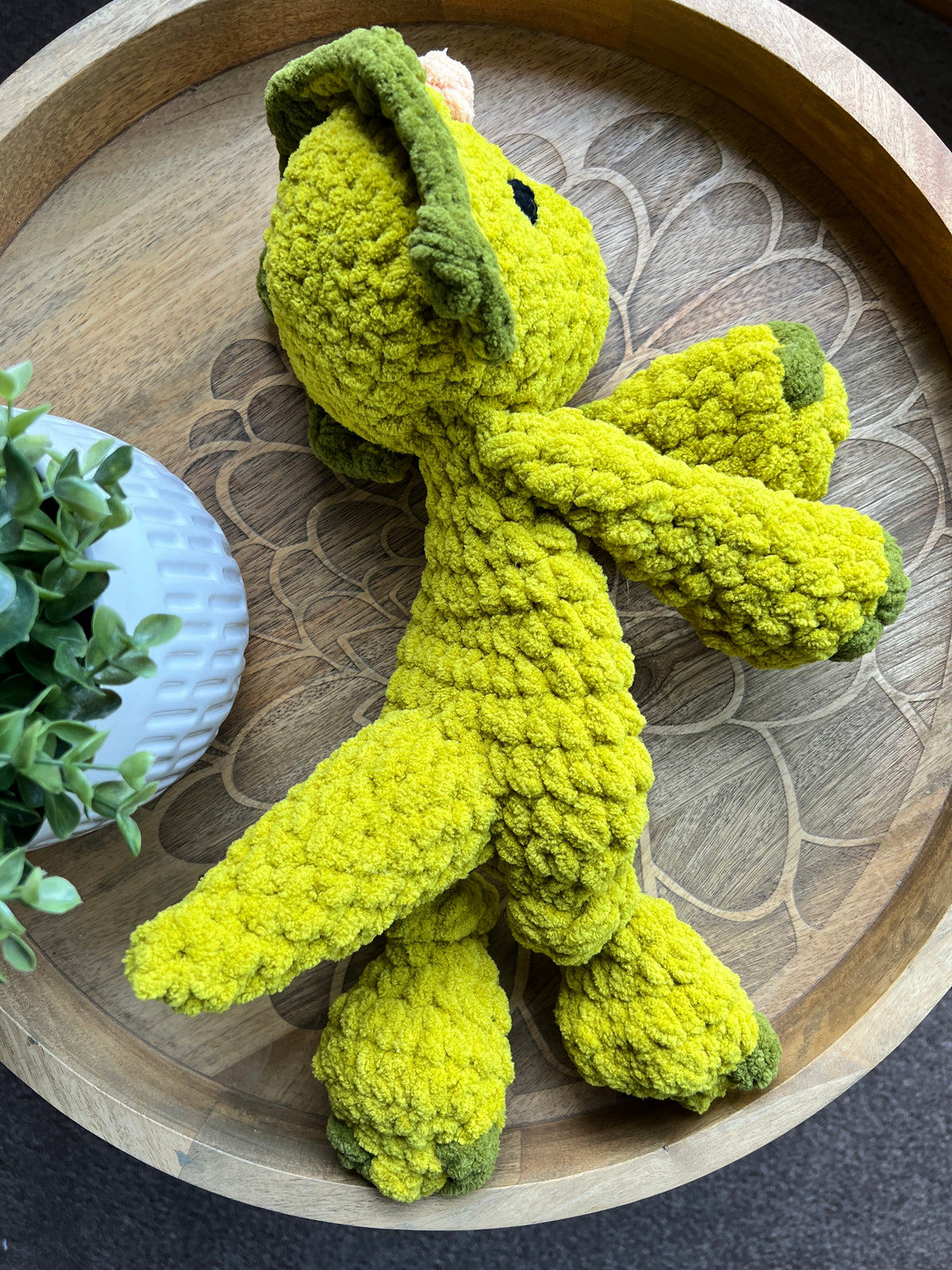 Handmade modern crochet Triceratops lovey snuggler with knotted legs baby safe.