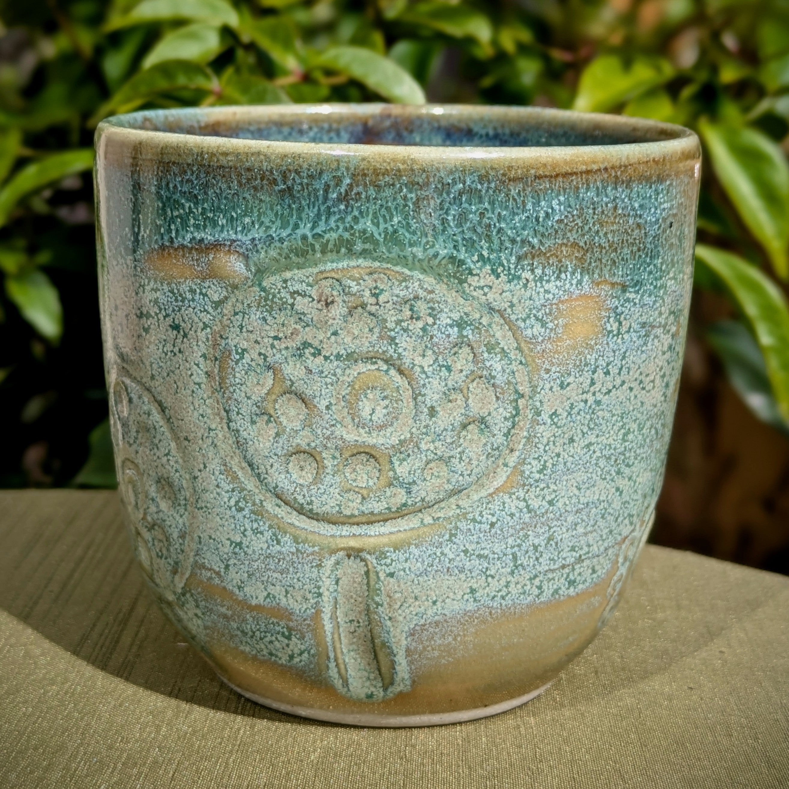 Cup in soft, mottled mossy greens and warm sandy colour