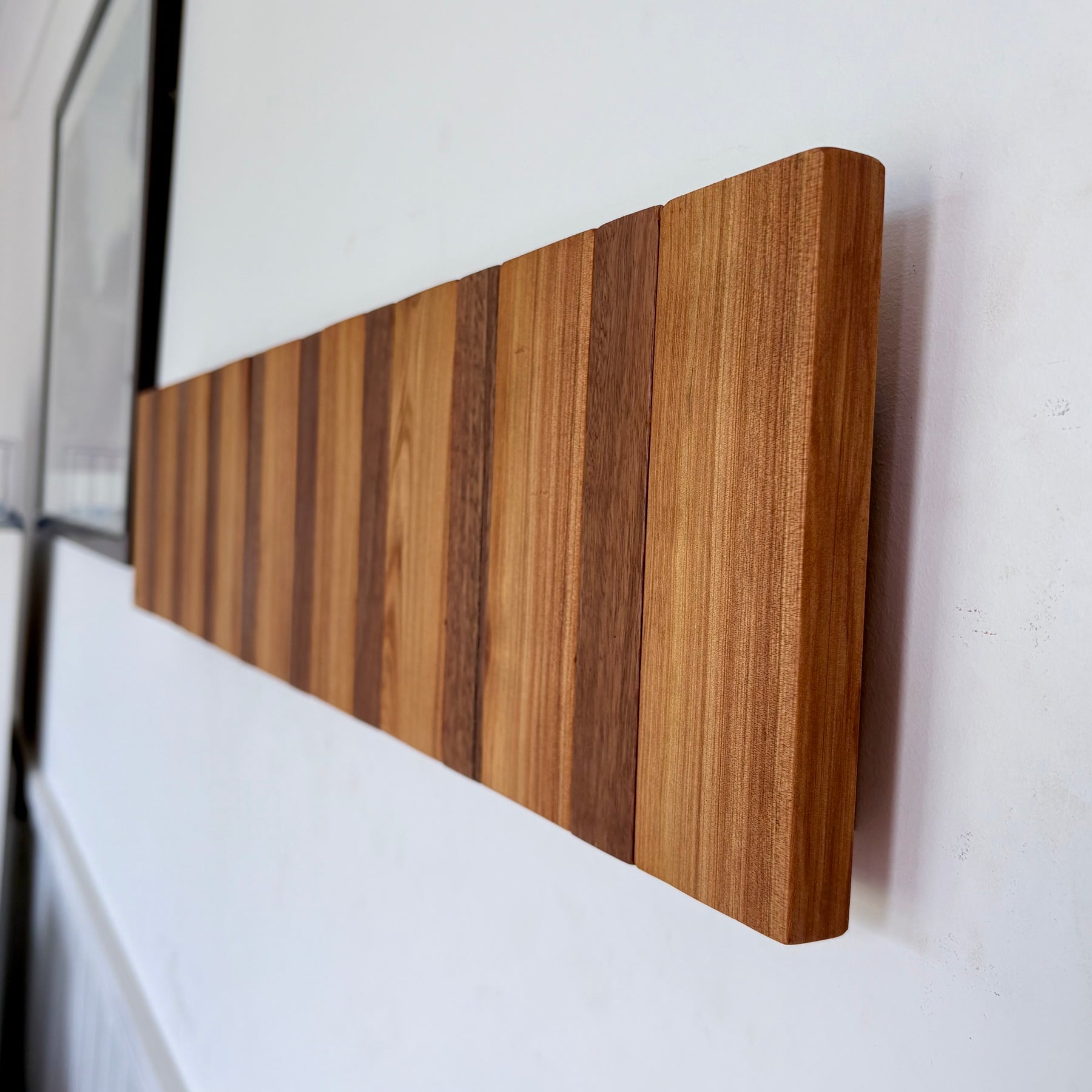 Two tone spotted gum and cypress horizon line piano style coatrack