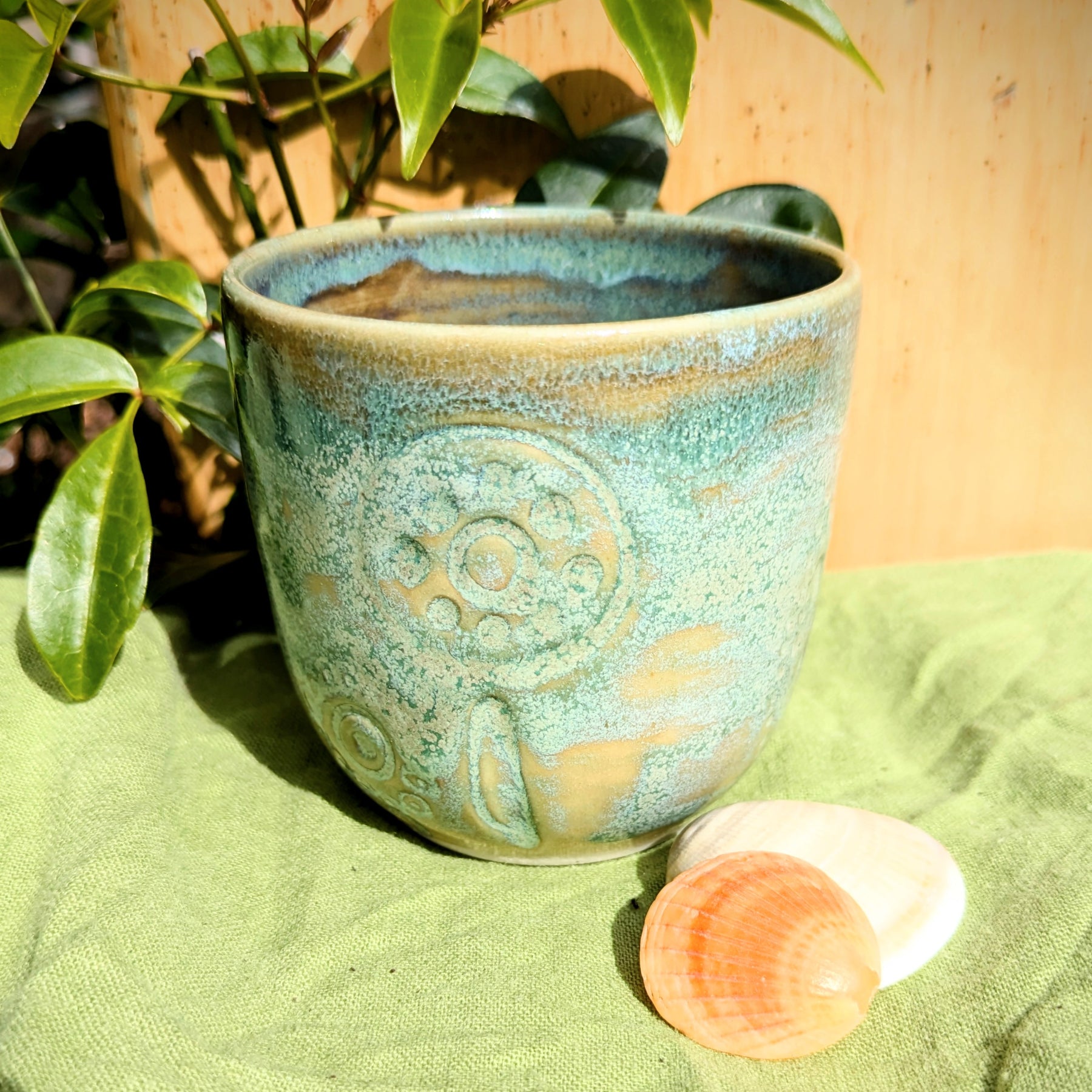 Cup in soft, mottled mossy greens and warm sandy colour