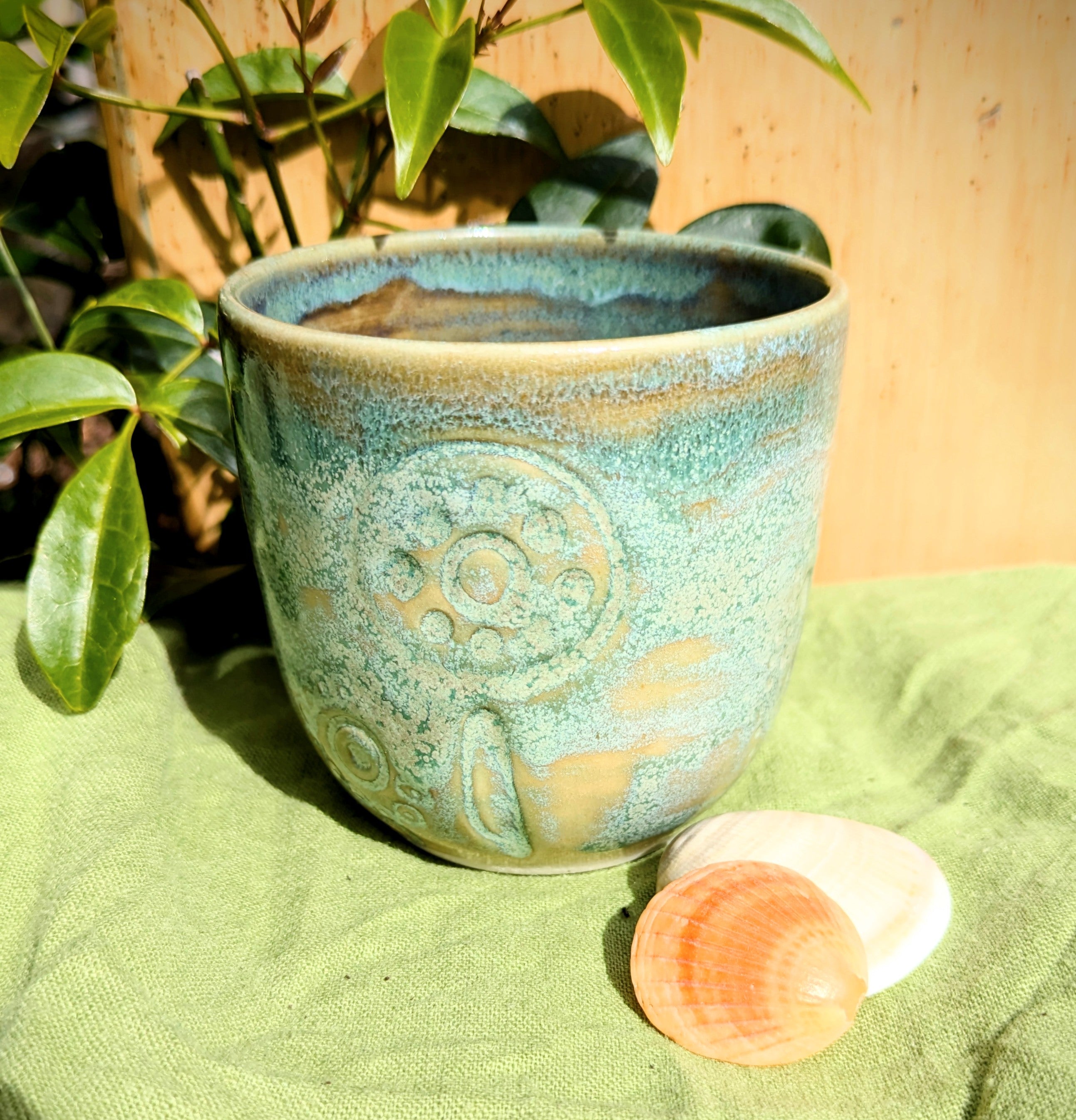 Cup in soft, mottled mossy greens and warm sandy colour