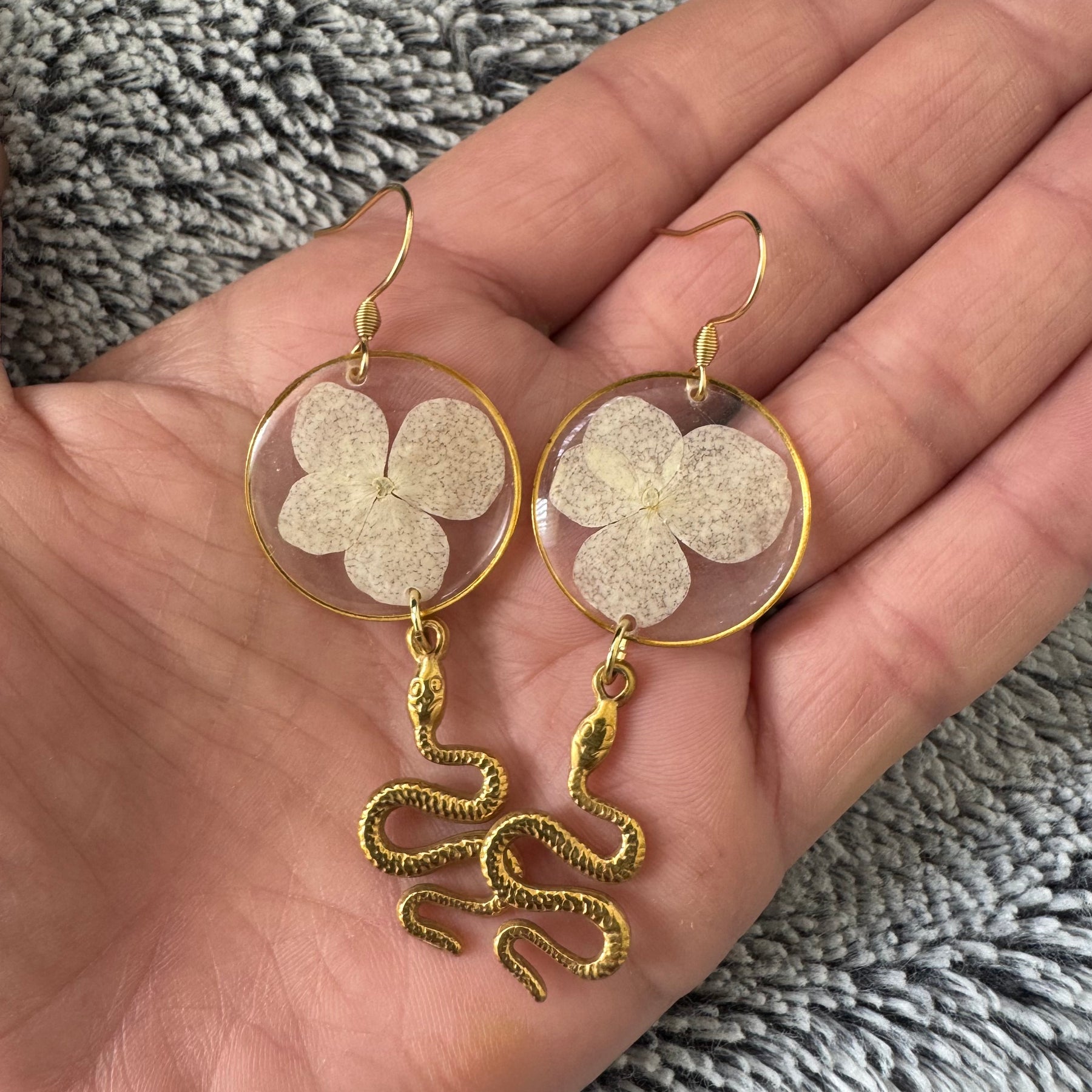 White pressed flower resin earrings with gold snake