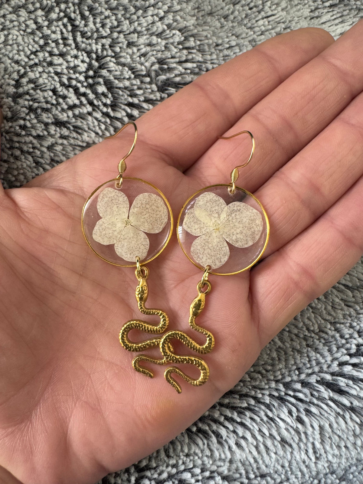White pressed flower resin earrings with gold snake