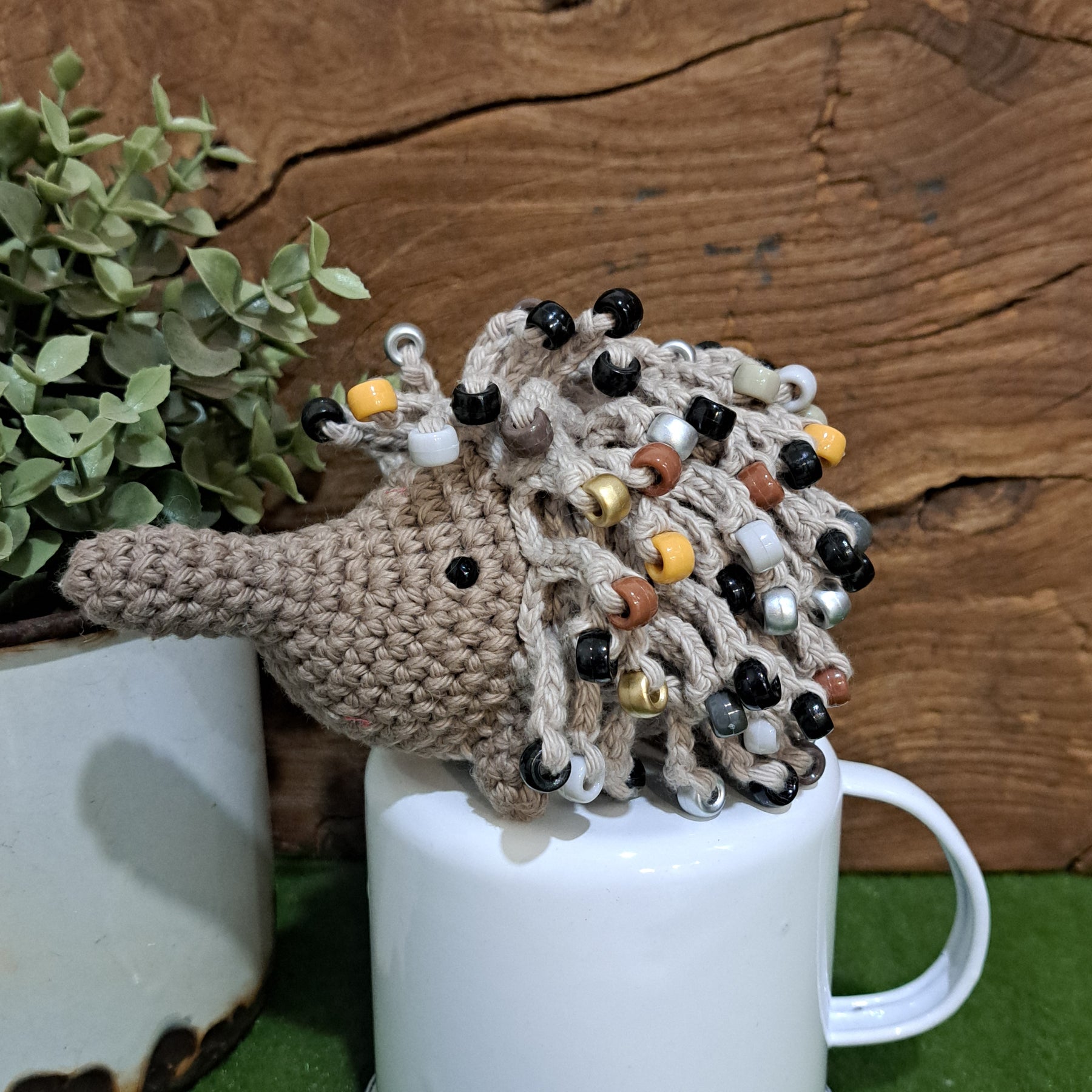 Handmade crochet echidna in beige cotton with neutral coloured beads