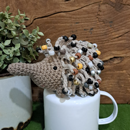 Handmade crochet echidna in beige cotton with neutral coloured beads