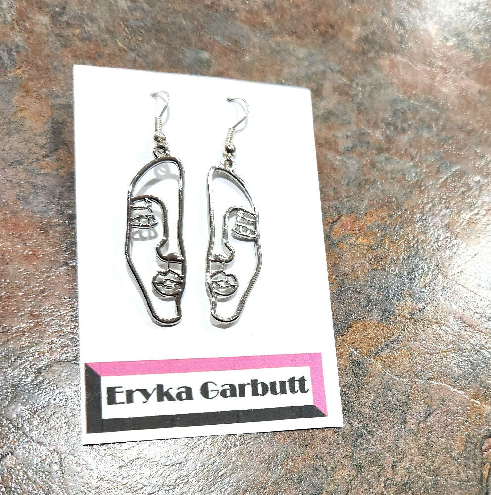 Dangle earrings. Face silhouette in gold or silver.