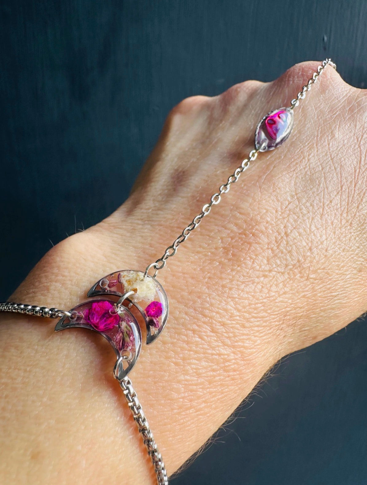 Botanical resin hand chain in silver with pressed flowers and cowrie shell