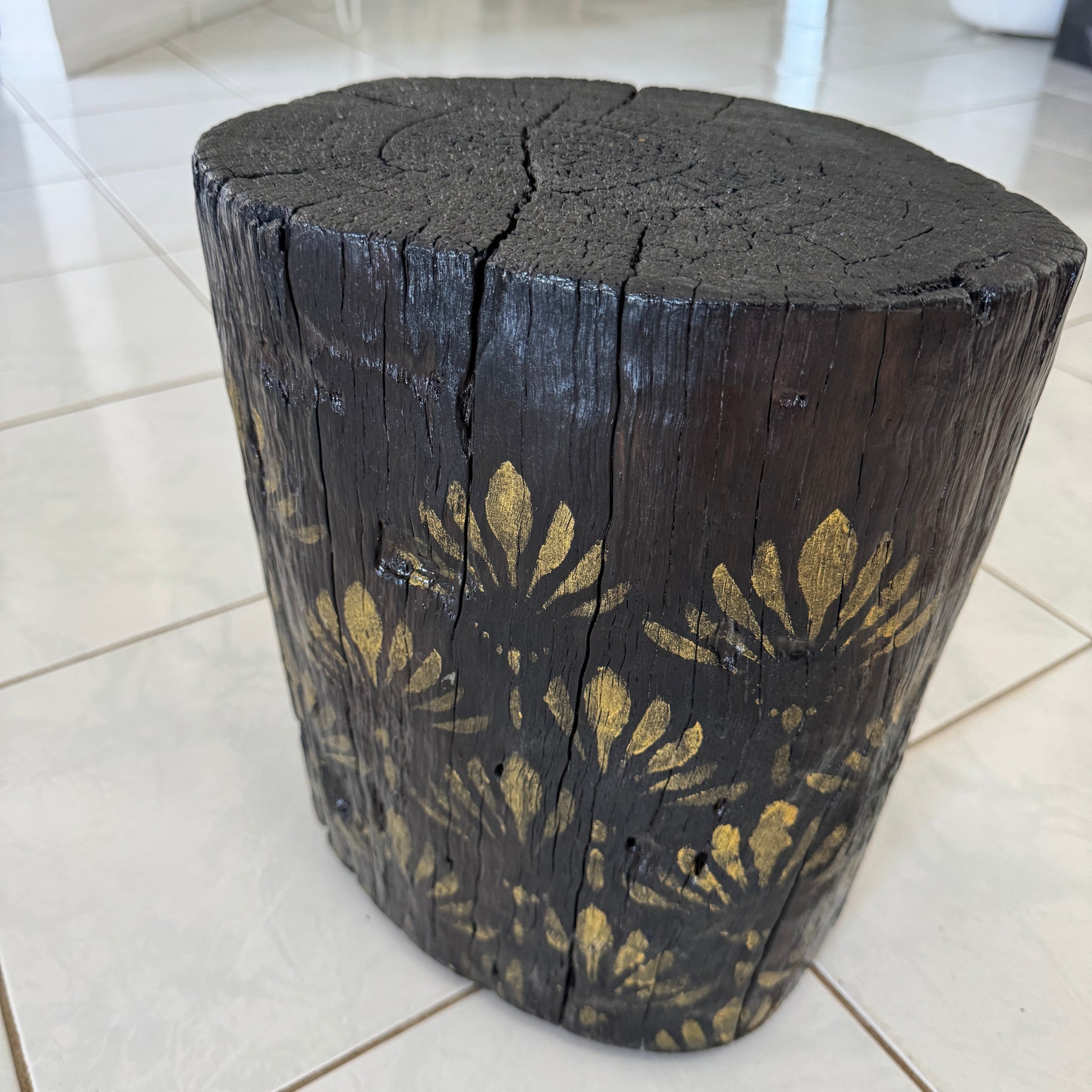 Burnt Timber stump table featuring gold hand-painted artwork