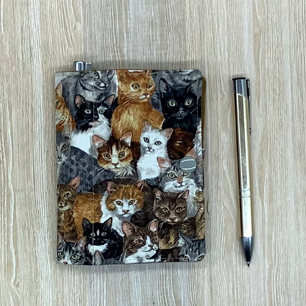 Cats refillable fabric pocket notepad cover with snap closure. Incl. book and pen.