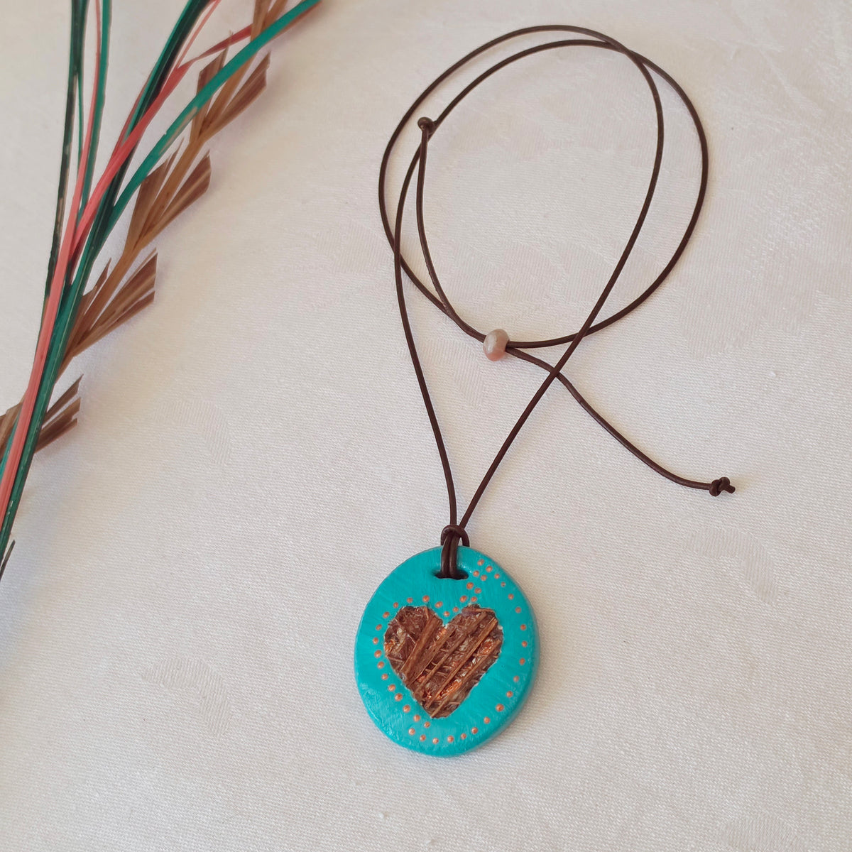 Hand-painted natural clay pendant with palm fibre heart