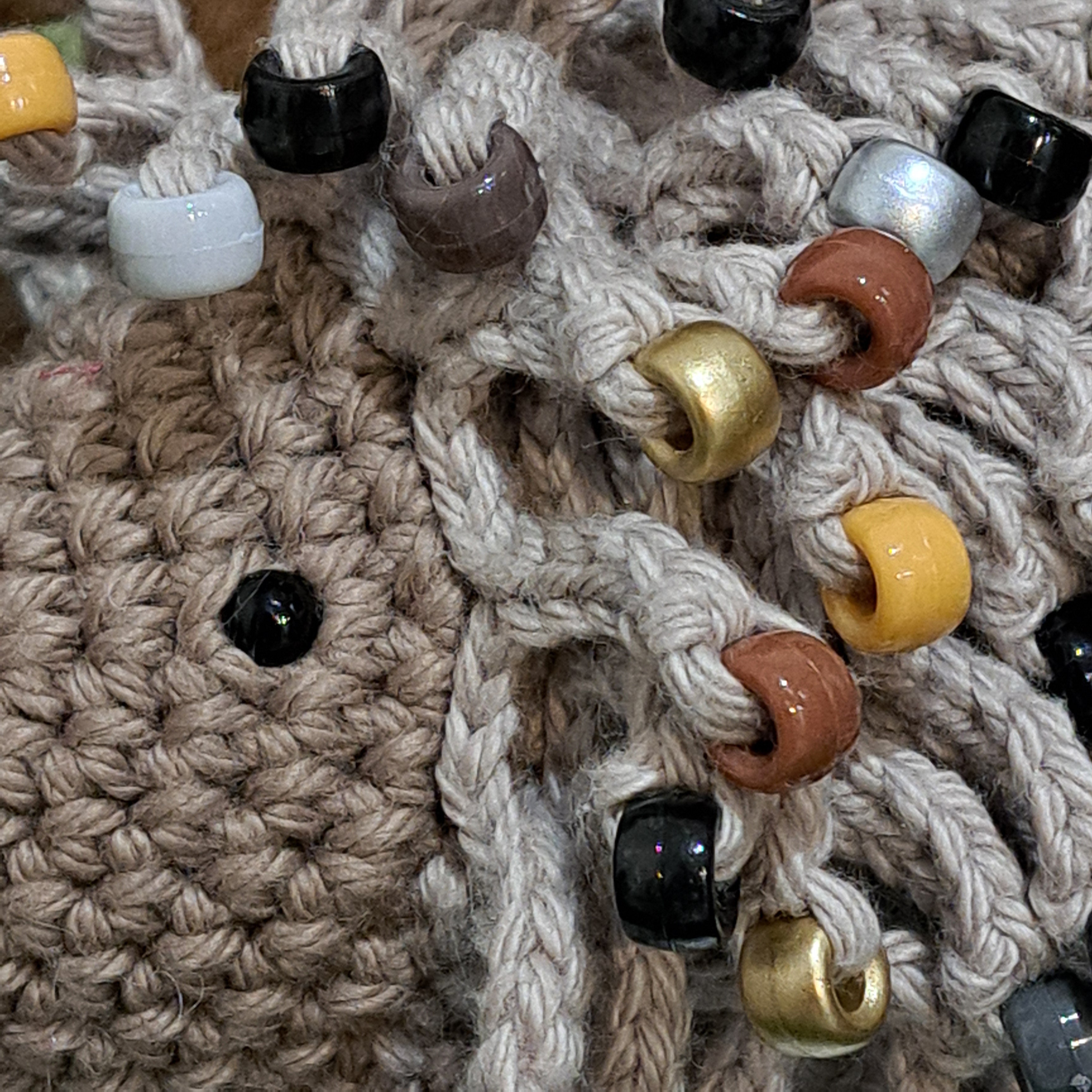 Handmade crochet echidna in beige cotton with neutral coloured beads