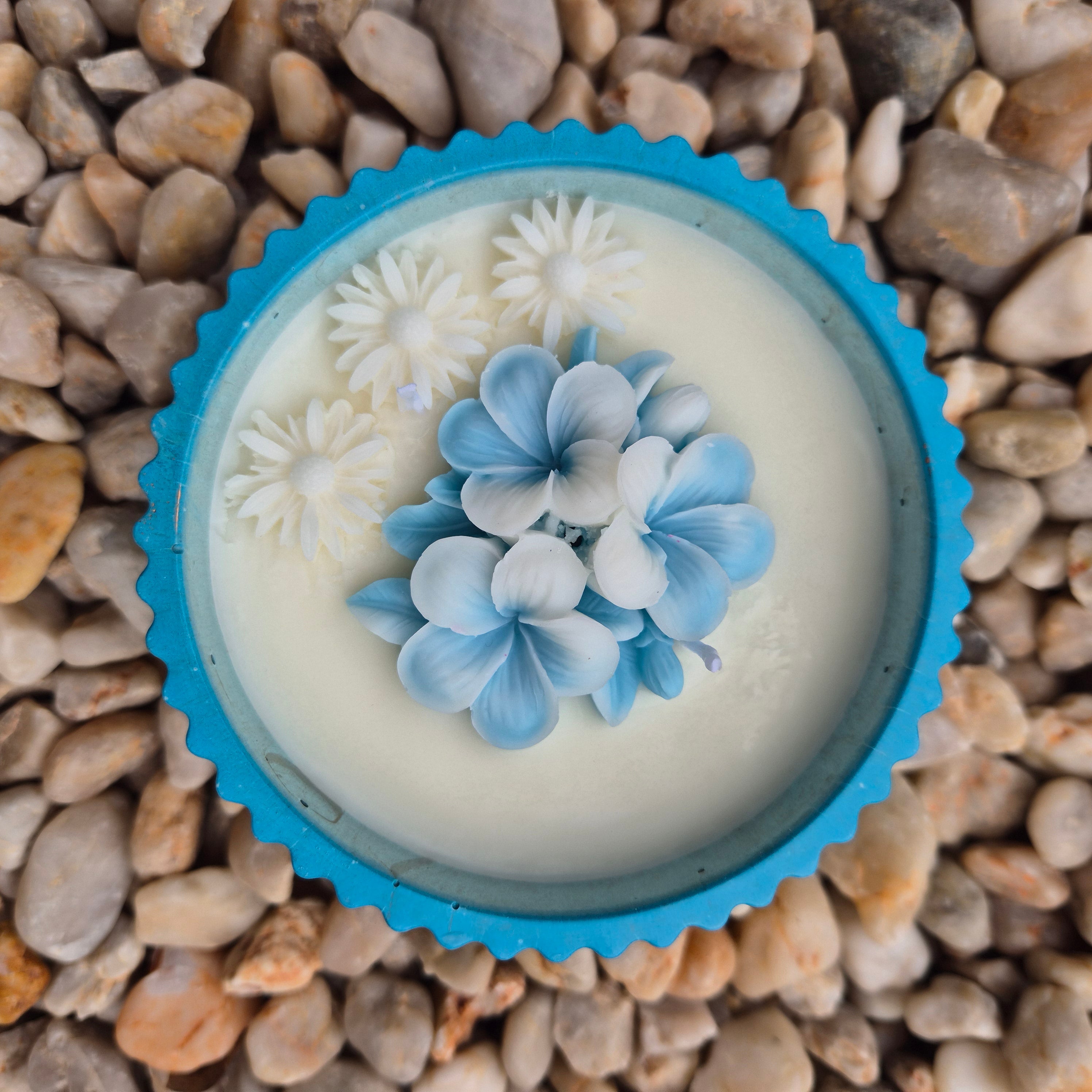 Round blue and gold concrete bowl candle with frangipani flower