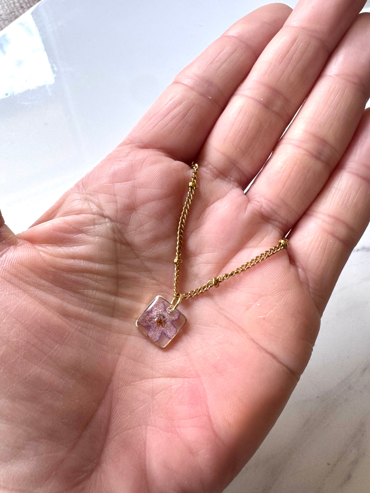Gold plated resin necklace with purple wildflower
