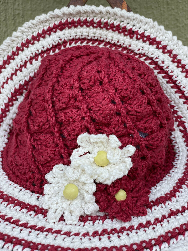 Cherry red spiral sun hat with daisy trim.