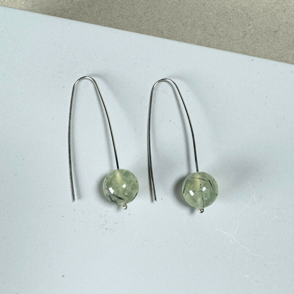 Prehnite earrings flat on mid-grey background