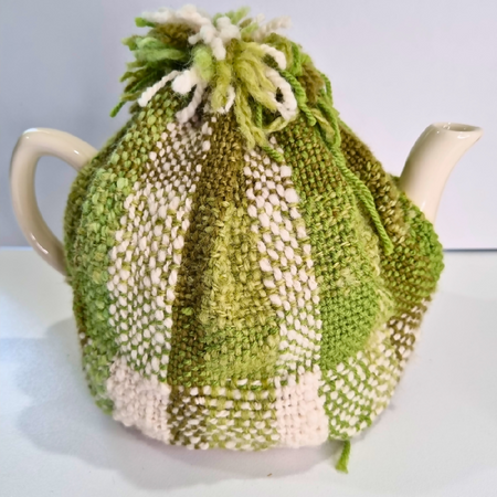 Handwoven green and white tea cosy