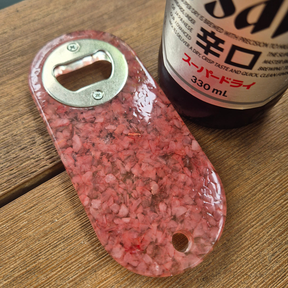 Resin bottle opener with inlaid rose quartz stones