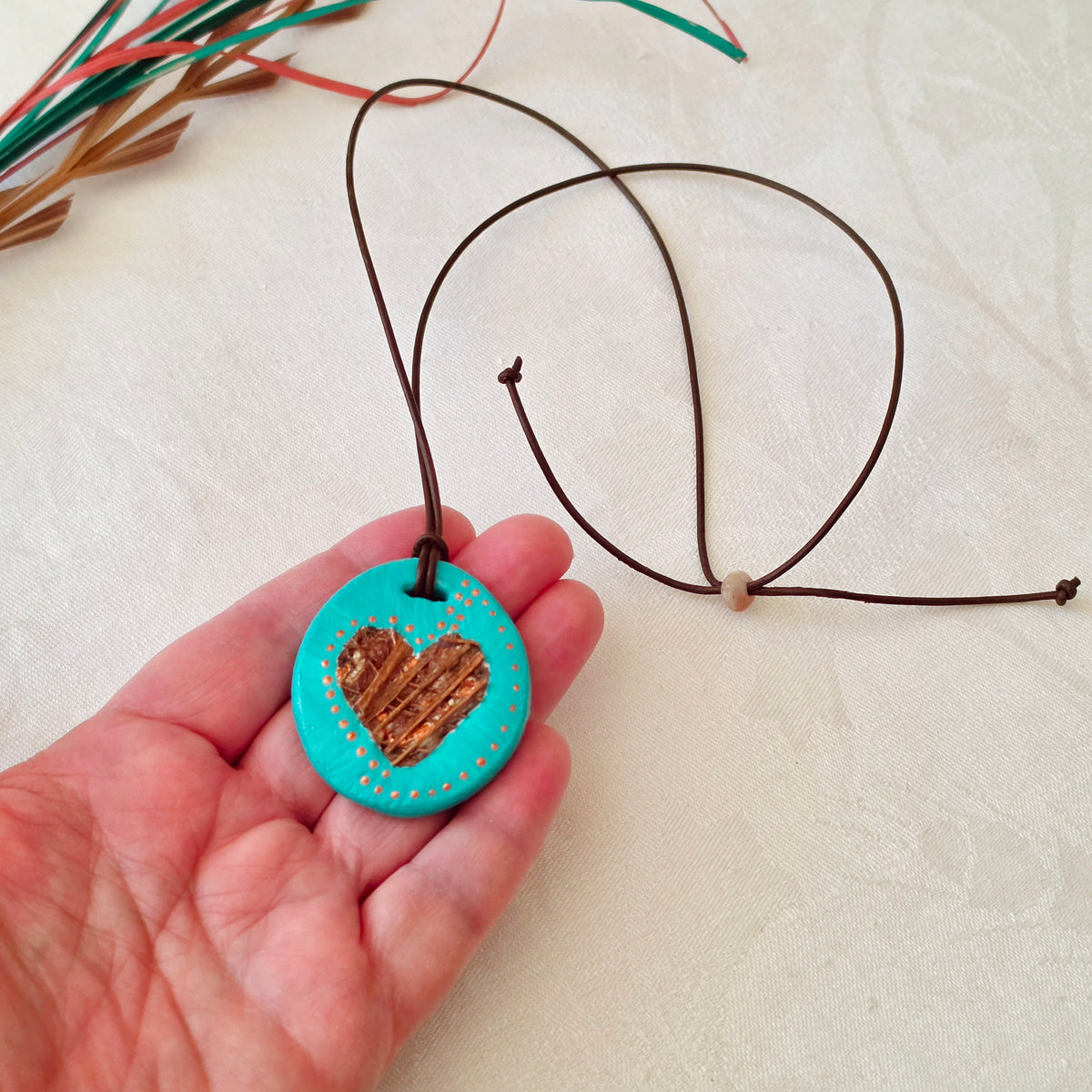 Hand-painted natural clay pendant with palm fibre heart