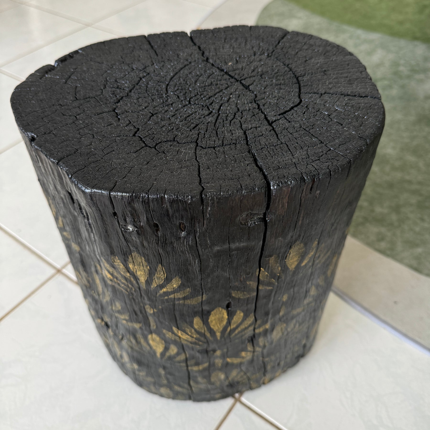 Burnt Timber stump table featuring gold hand-painted artwork