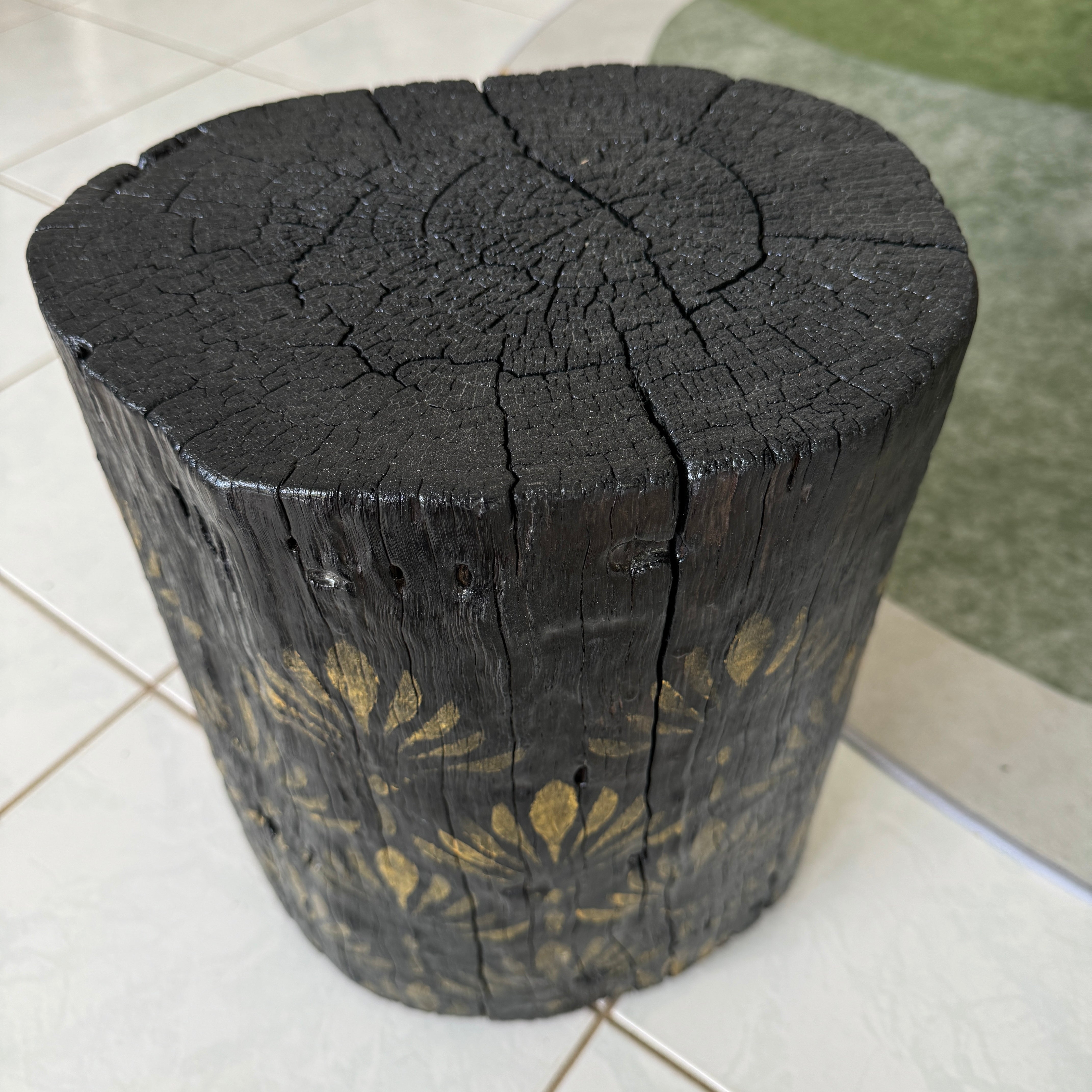 Burnt Timber stump table featuring gold hand-painted artwork