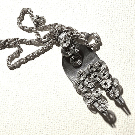 Recycled cutlery pendant with Egyptian coiled wire.