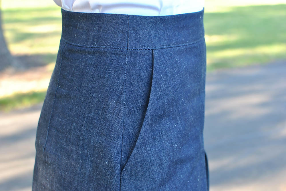 Details of adenim skirt. A woman is wearing it with white shirt.