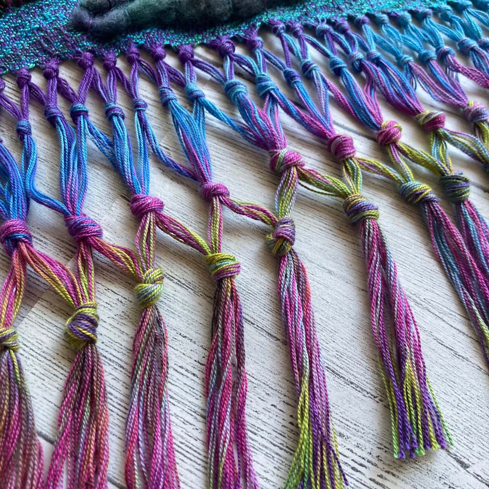 handwoven-wall-hanging-rainbow-entangled-happiness-handwovens-closeup-fringe-pink