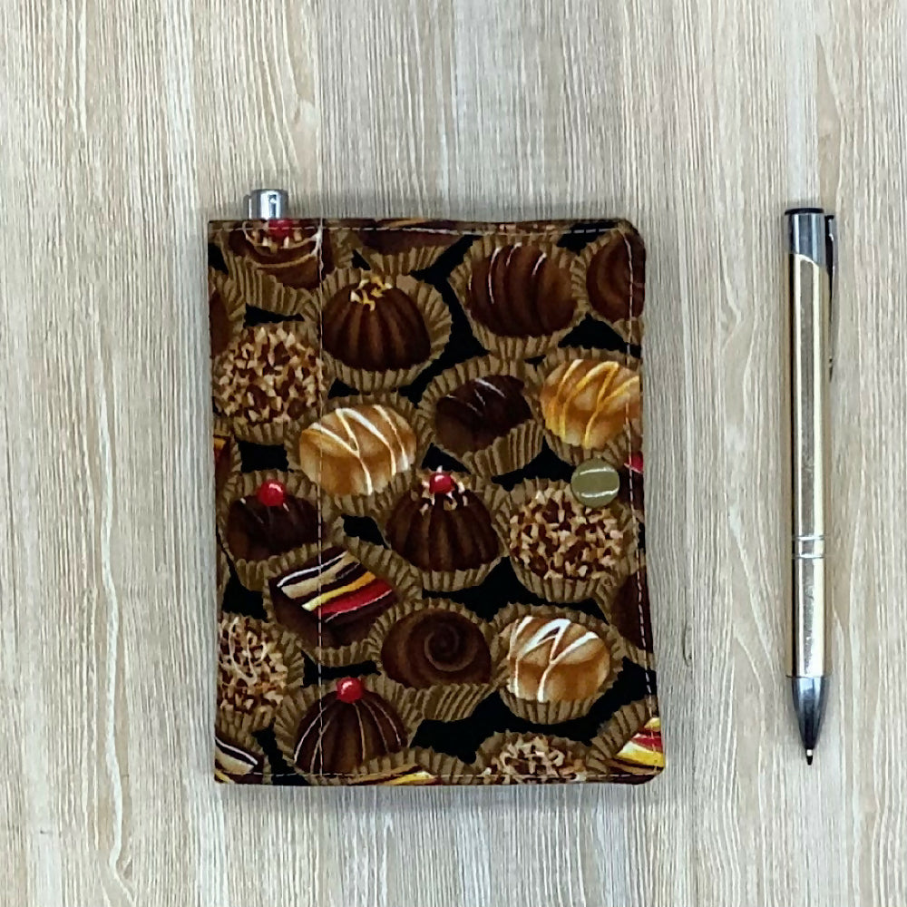 Chocolates refillable fabric pocket notepad cover with snap closure. Incl. book and pen.