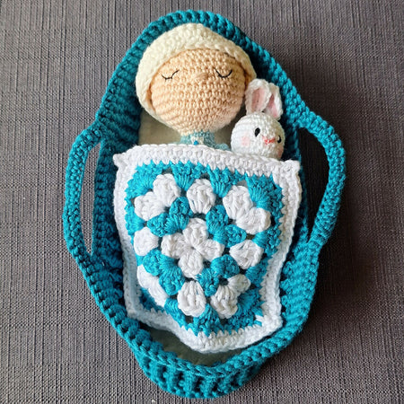 crocheted baby doll in carry basket