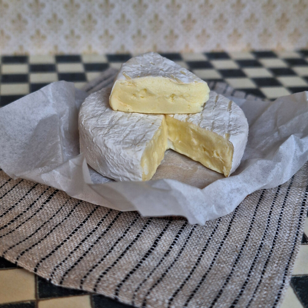 LARGE BRIE cheese with a cut wedge
