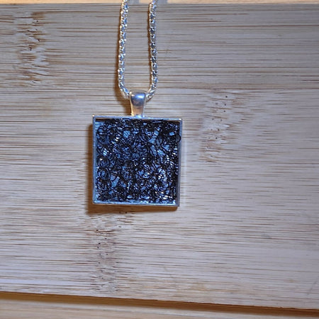 Pendant necklace. Black crochet wire in silver frame.