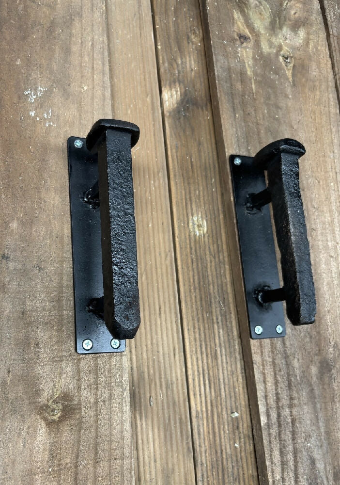 Railway spike door handle pair on wooden door