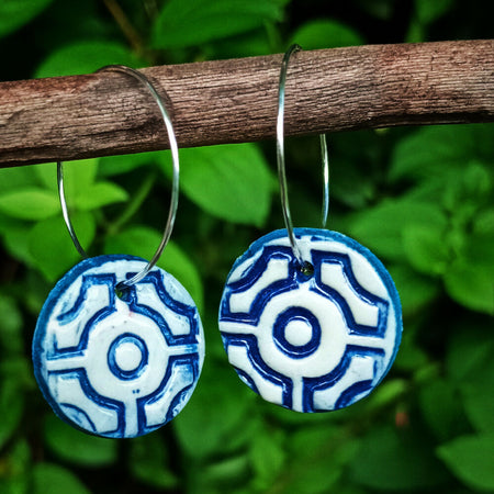 Blue and white geometric design earrings on silver hoops