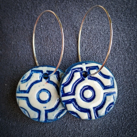 Blue and white geometric design earrings on silver hoops