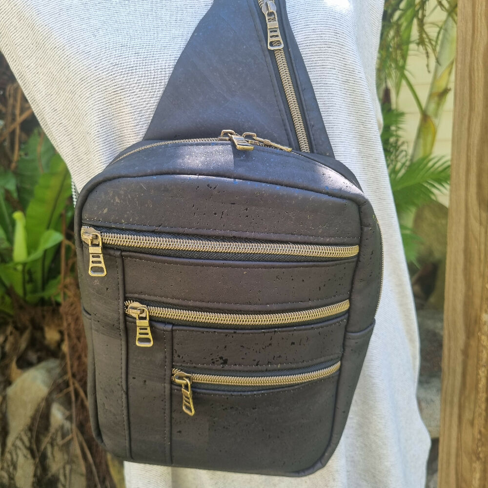 Handmade Black cork sling style bag, showing four zipper pockets.