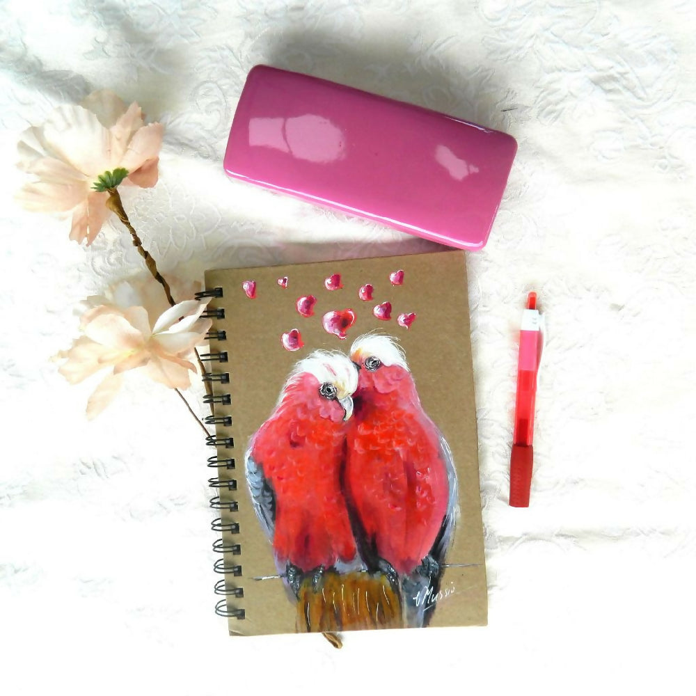 galahs with glass case, pen and flower on cloth