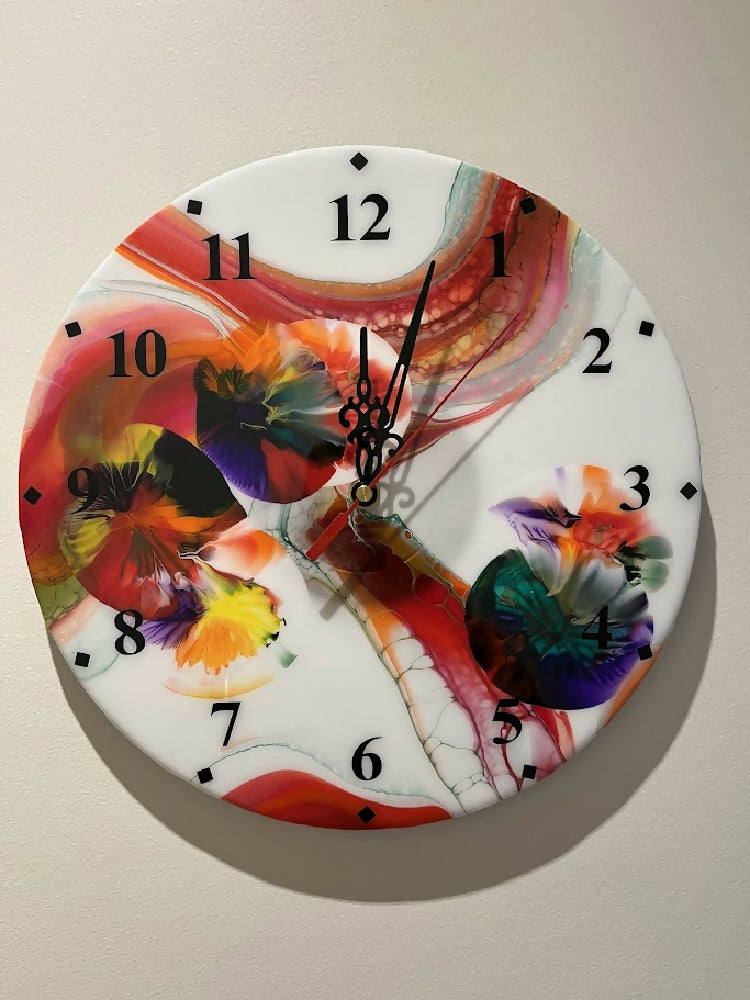 Multi-coloured clock with black nos and hands