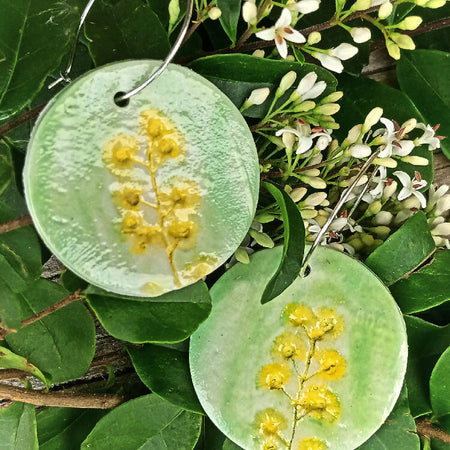 Large round ceramic earrings with yellow wattle flowers on green